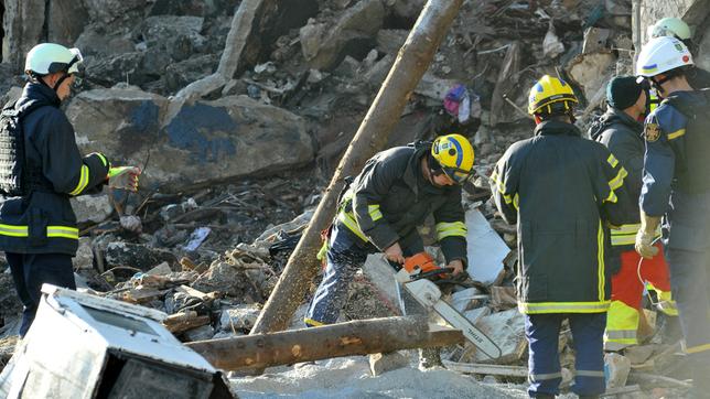 Feuerwehrleute arbeiten in Trümmern.