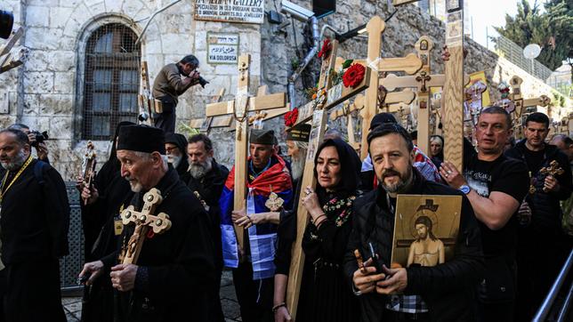 Menschen mit Holzkreuzen bei einer Prozession
