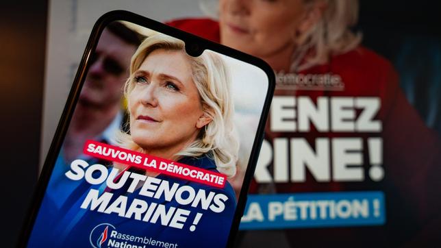 Foto von Marine Le Pen mit Unterstützungsparolen auf einem Mobiltelefon