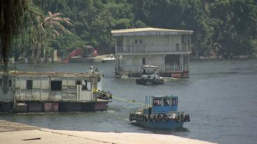 Hausboot wird von Schlepper abgeschleppt 