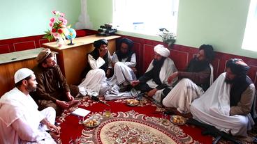 Taliban sitzen auf Fußboden im Kreis