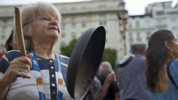 Frau schlägt bei Demonstration auf Pfanne 