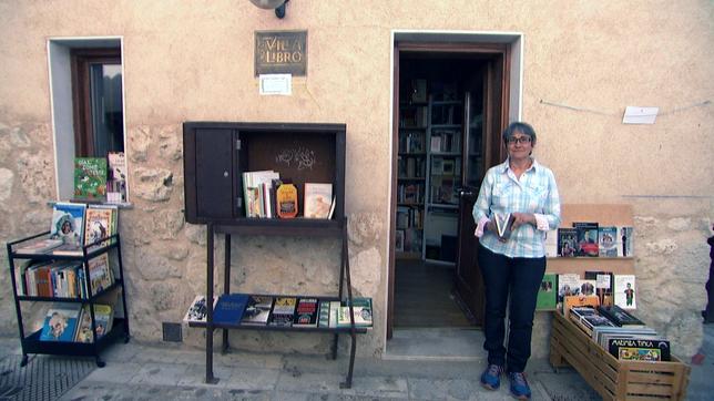 Eine Frau mit Büchern vor einem Haus