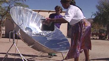 Eine Frau an einem Solarkocher