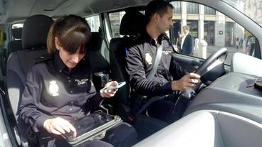 Zwei Polizisten mit Tablet und Smartphone