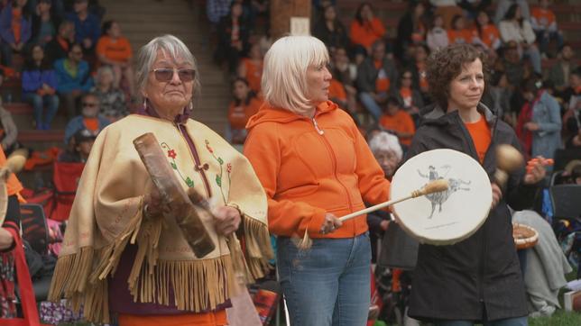 Drei Frauen protestieren, zwei davon mit Trommeln.