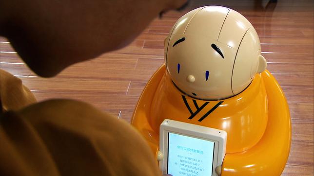 Ein kleiner, gelber Robot-Mönch lehrt den chinesischen Buddhismus.