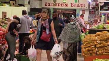 Menschen beim Einkaufen in Markthalle