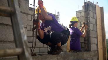 Zwei Helferinnen arbeiten an einer Mauer auf Baustelle 