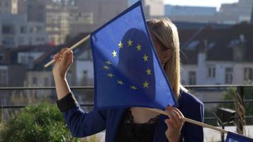 Diana zur Löwen hält sich Europa-Fahne vor das Gesicht