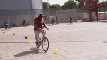 Frau fährt Kurven zwischen Hütchen bei Fahrradtraining