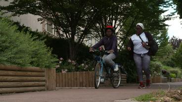 Mutter unterwegs mit Kind das Fahrrad fährt 