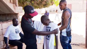 Bild: NDR Ein Mann verteilt T-Shirts mit dem Aufdruck "Gambia has decided".