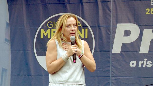 Eine Frau redet in ein Mikrofon auf einer Parteiveranstaltung.