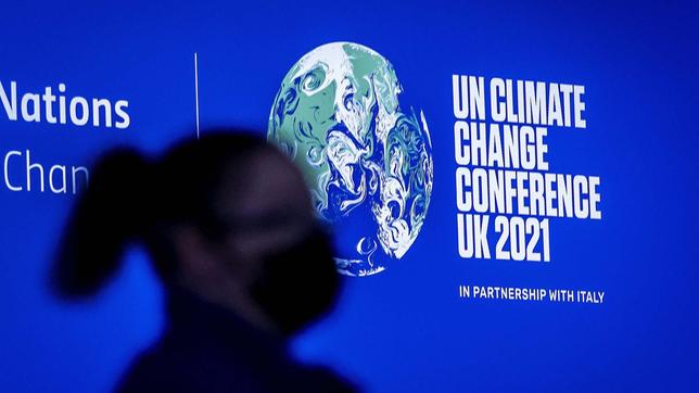 Teilnehmerin bei Klimakonferenz vor Schriftzug "UN Climate Change Conference UK 2021 "