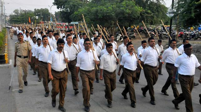 Männer in Uniform und mit Stöcken marschieren 