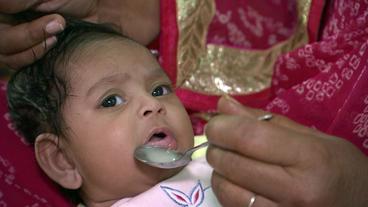 Ein Baby wird mit Milch gefüttert.