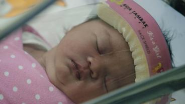 Neugeborenes Baby mit Gesichts-Schutzschild