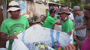 Müllsammler mit Sack voller Plastikflaschen