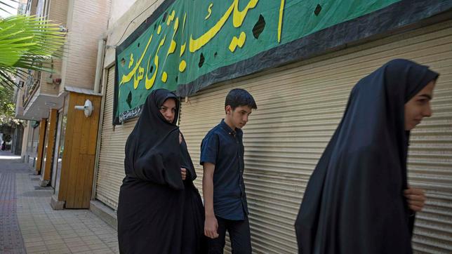 Isfahan/Iran: zwei verschleierte Frauen und ein Mann auf der Straße 