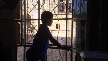 Yussuf schaut in Hebron aus einem Fenster.