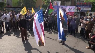 Brennende Fahnen der USA und Israels bei Demonstration im Iran
