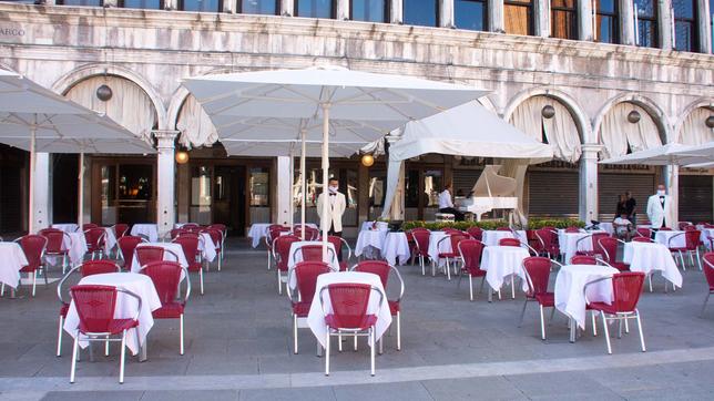 Leere Stühle vor Restaurant am Markusplatz in Venedig