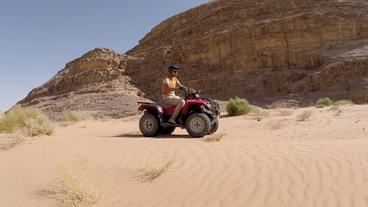 Mann fährt auf Quad durch die Wüste