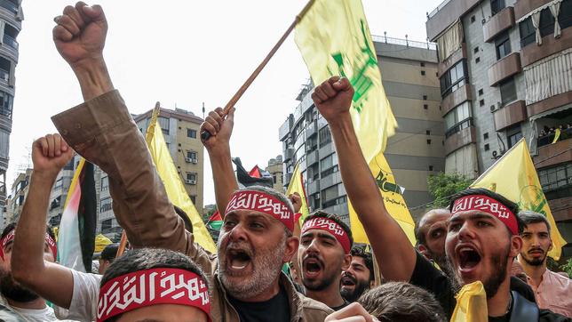 Menschen schwenken Hisbollah-Fahnen, während einer Solidaritätsdemonstration mit den Palästinensern.