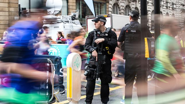 Bewaffnete Polizisten stehen an der Kreuzung Portland Street/Oxford Street in Manchester.