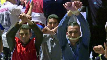 Demonstranten mit zugeklebtem Mund und gefesselten Händen