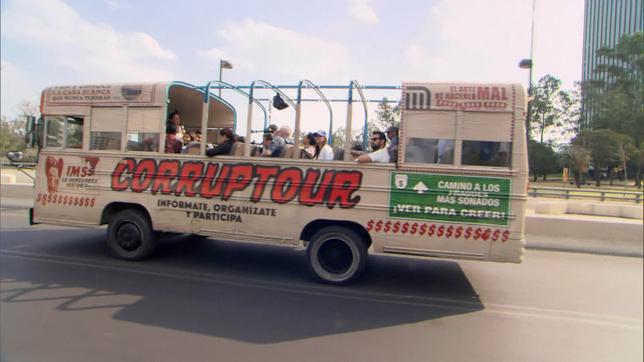 Ein halb offener Stadtrundfahrtbus mit der Aufschrift "Corruptour"