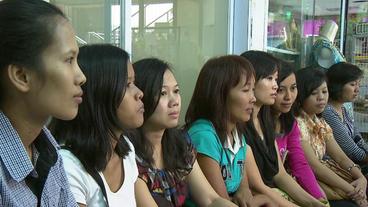 Junge Frauen sitzen in einem Shoppingcenter und warten auf einen Arbeitgeber.