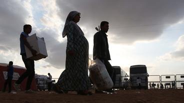 Flüchtlinge aus Syrien überqueren die türkische Grenze.