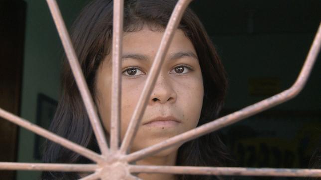 Alini, 13 Jahre alt und Kinderprostituierte in Fortaleza, schaut durch ein Gitter.