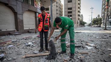 Zwei Männer sehen sich Überreste eines Geschosses in Gaza City an