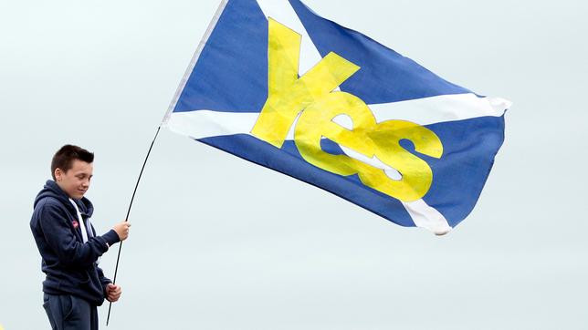 Ein Junge hält eine Fahne für die schottische Unabhängigkeit.
