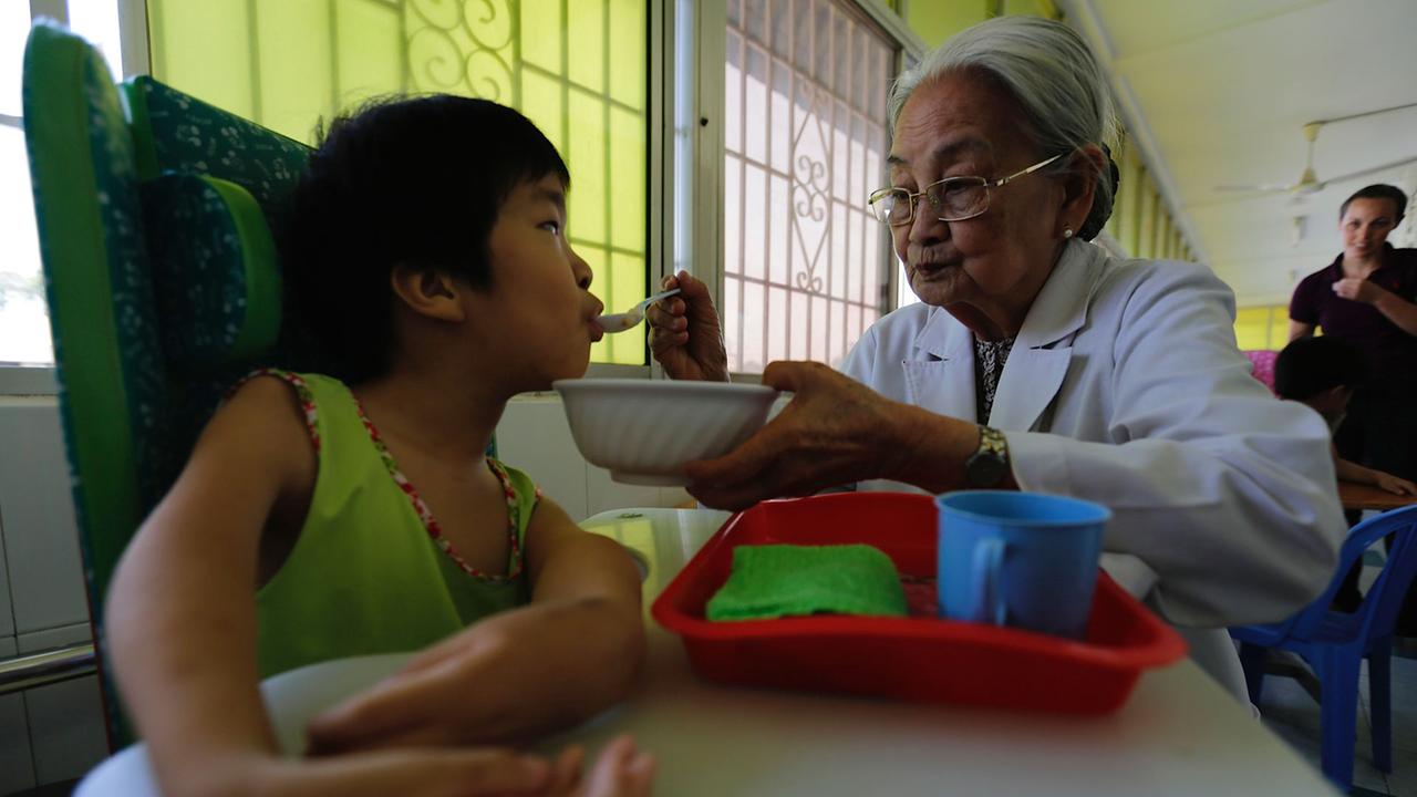 Dr. Ta Thi Chung füttert ein Kind im Krankenhaus in Saigon