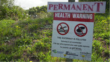 Schild mit Warnung vor  verschmutztem Wasser