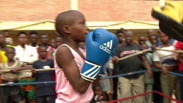 Kind boxt mit Boxhandschuhen