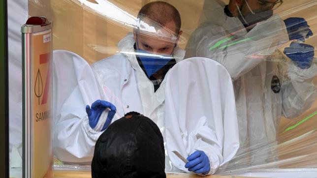 Eine Person wird an einer Covid-Teststation einer Apotheke mit einem Antigen-Schnelltest auf das Coronavirus getestet.