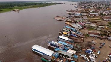 Amazonas mit Schiffen und Hütten Ufer