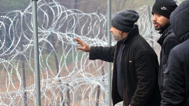 Flüchtlinge an Stacheldrahtzaun