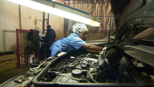 Frau repariert Motor von Auot