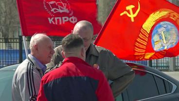 Männer mit kommunistischen Fahnen