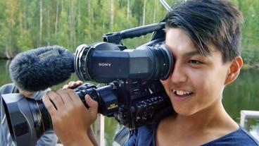 Ali, 14 Jahre aus Afghanistan, hält eine Fernsehkamera.
