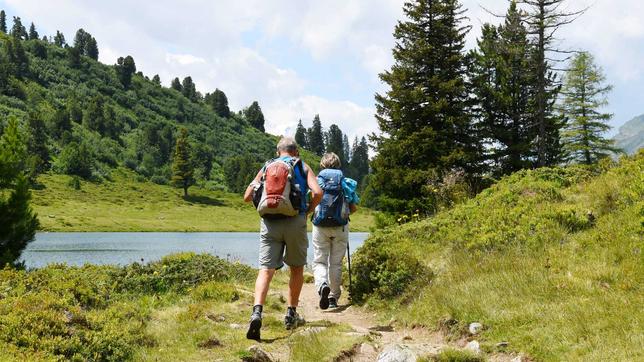 Zwei Wanderer mit Rucksack unterwegs in bergiger Landschaft