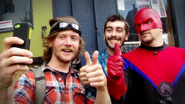 Passanten schießen Selfies mit dem Superhelden "Watchman".