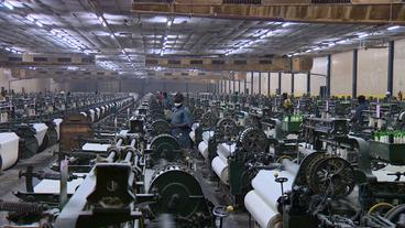 Arbeiter und Maschinen in einer Textilfabrik 