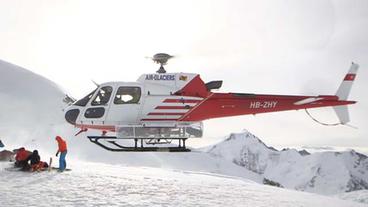 Hubschrauber landet auf verschneitem Berg 